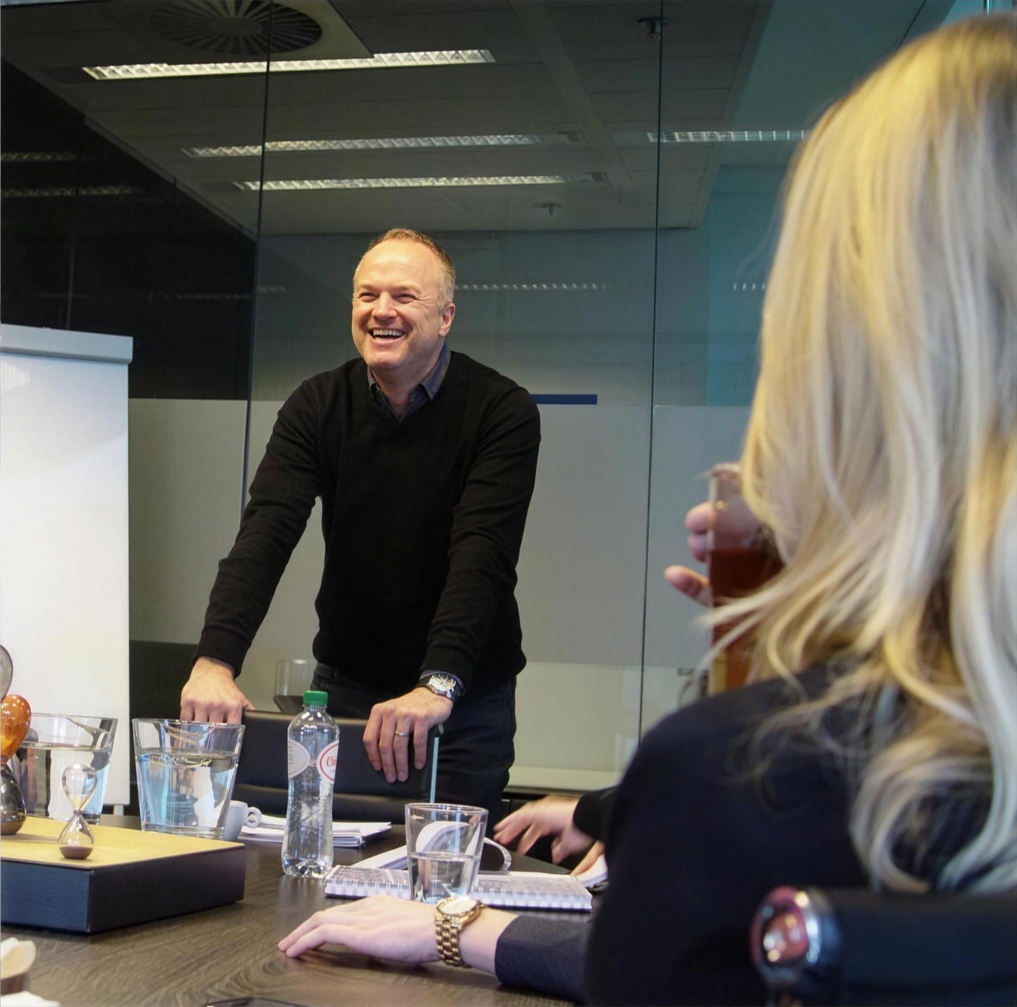 Lachende ondernemer in overleg aan tafel, beeld uit de Victor Brands-site